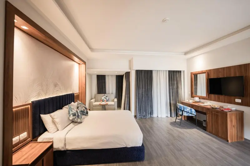 Une chambre lumineuse avec un grand lit et un coin salon.