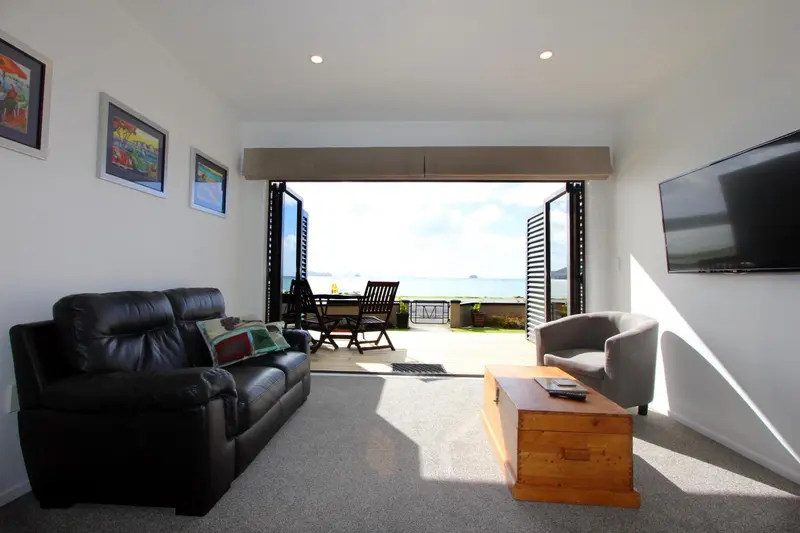 Un salon lumineux s'ouvre sur une terrasse avec vue sur la mer.