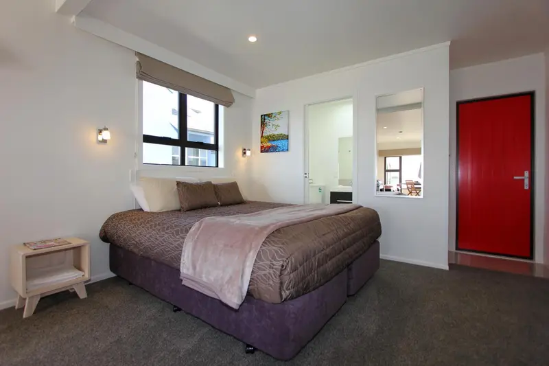 Une chambre lumineuse avec un grand lit et une décoration sobre.