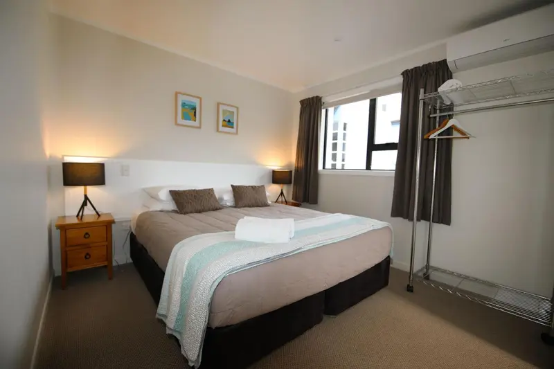 Une chambre lumineuse avec un grand lit et une décoration sobre.