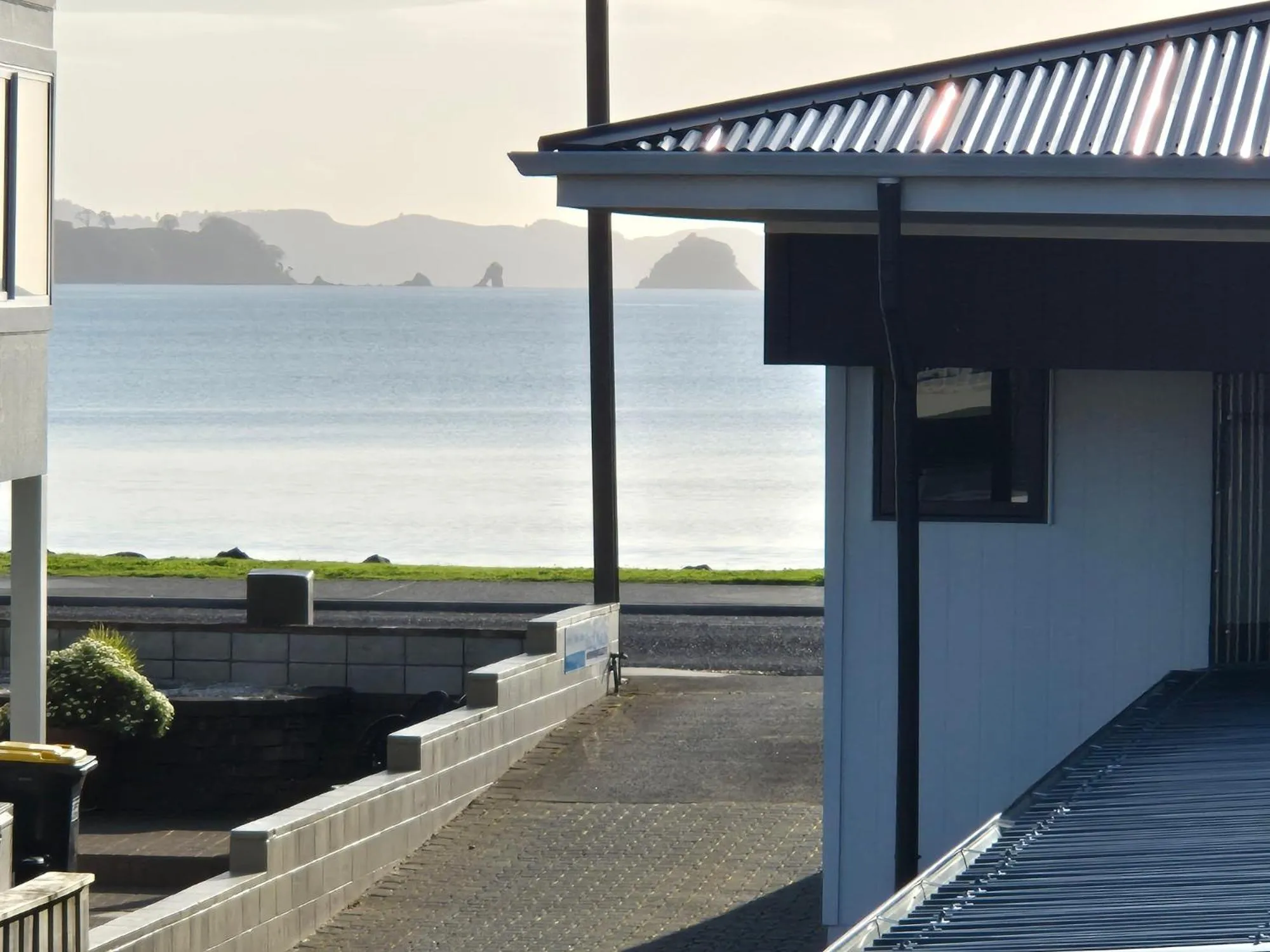 Vue sur la mer depuis une terrasse ombragée.