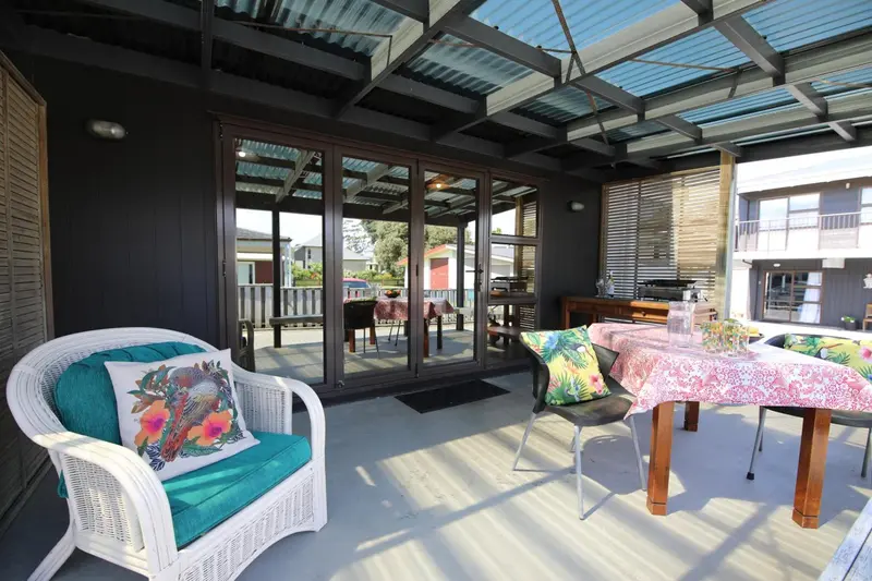 Terrasse ombragée avec mobilier de jardin et table à manger.