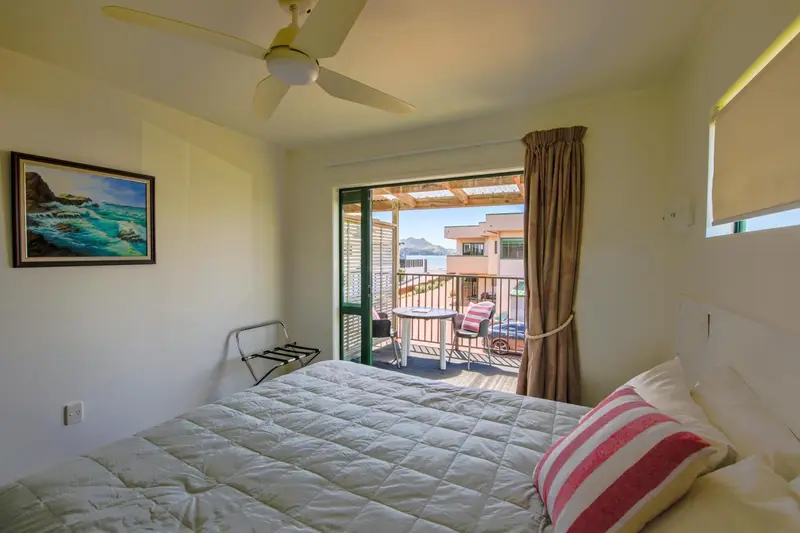 Une chambre lumineuse s'ouvre sur une terrasse avec vue sur la mer.