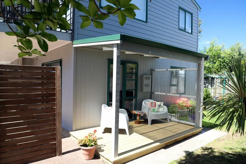 Terrasse ombragée avec mobilier de jardin et végétation.