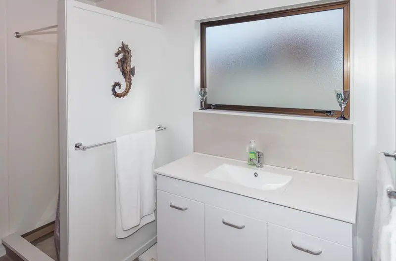 Une salle de bain claire avec une douche et un lavabo.