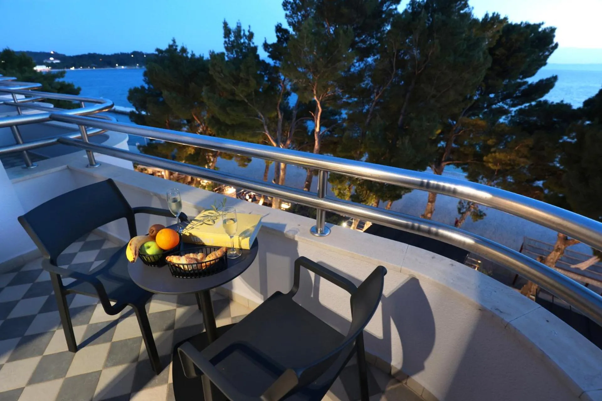 Une table basse avec des fruits et des boissons sur une terrasse avec des chaises.