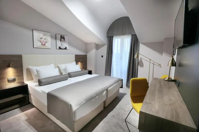Une chambre moderne avec un grand lit et un bureau jaune.