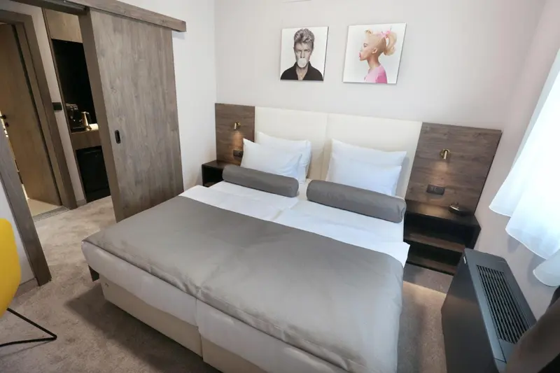Une chambre avec un grand lit et des illustrations murales.