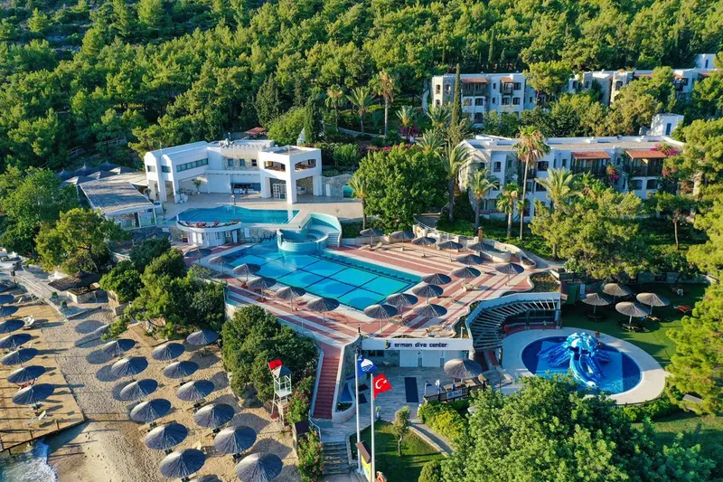 Vue aérienne d'un complexe hôtelier avec piscine et plage.
