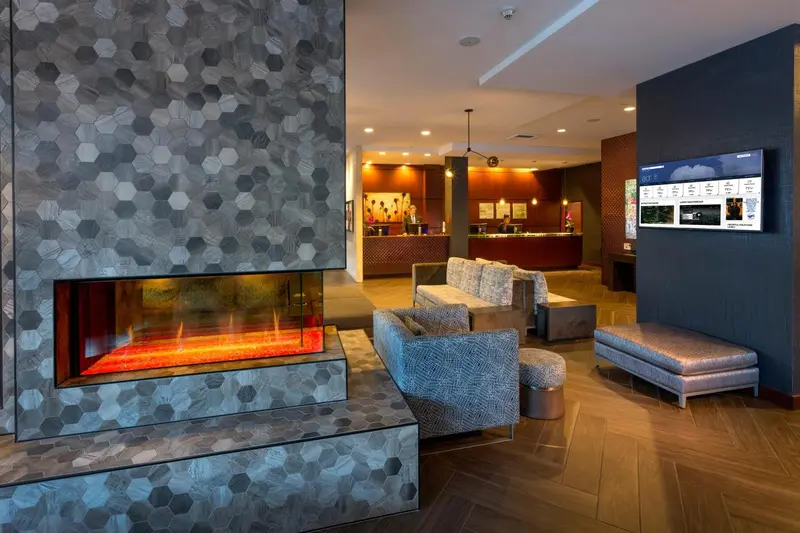 Un espace de réception moderne avec une cheminée et des canapés.
