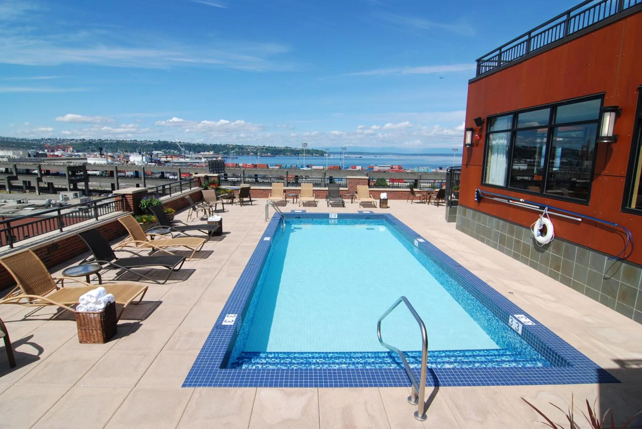 Terrasse avec piscine et mobilier de détente ensoleillé.