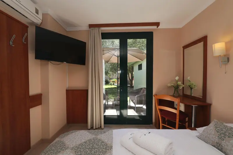 Une chambre lumineuse avec un lit soigné et un accès à une terrasse.
