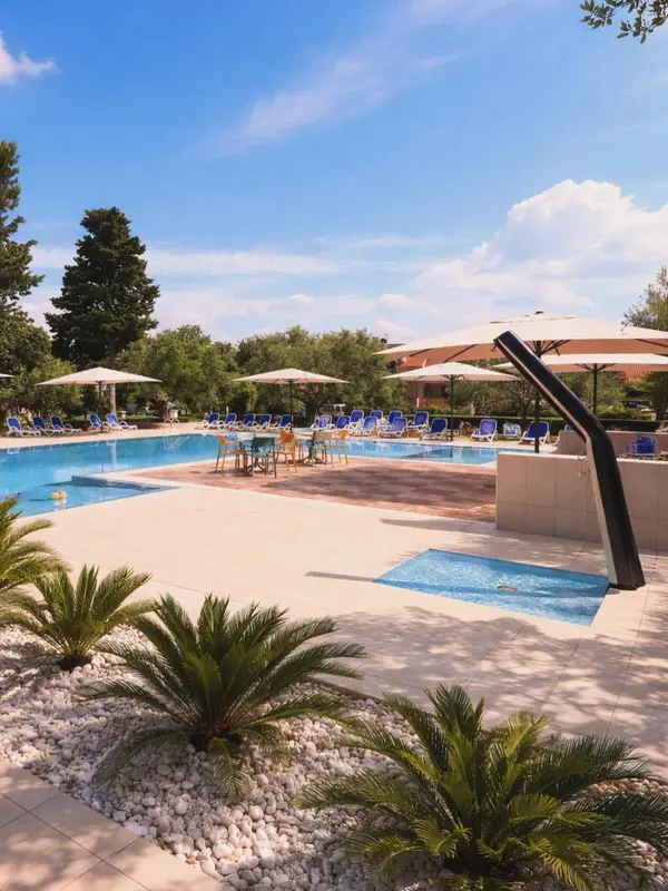 Transats bleus alignés au bord d'une piscine ensoleillée, avec des parasols et une végétation luxuriante.