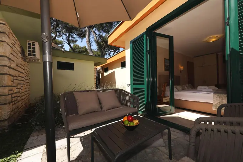 Terrasse aménagée avec salon et vue sur une chambre.