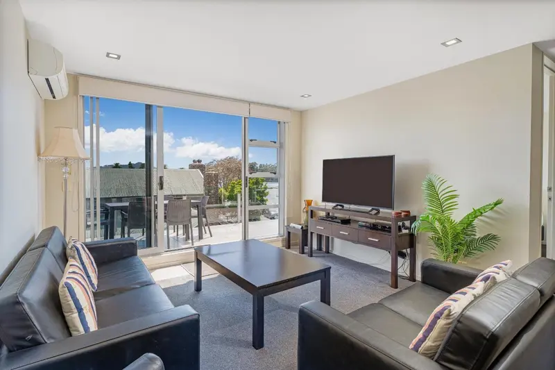 Un salon lumineux s'ouvre sur une terrasse avec vue dégagée.