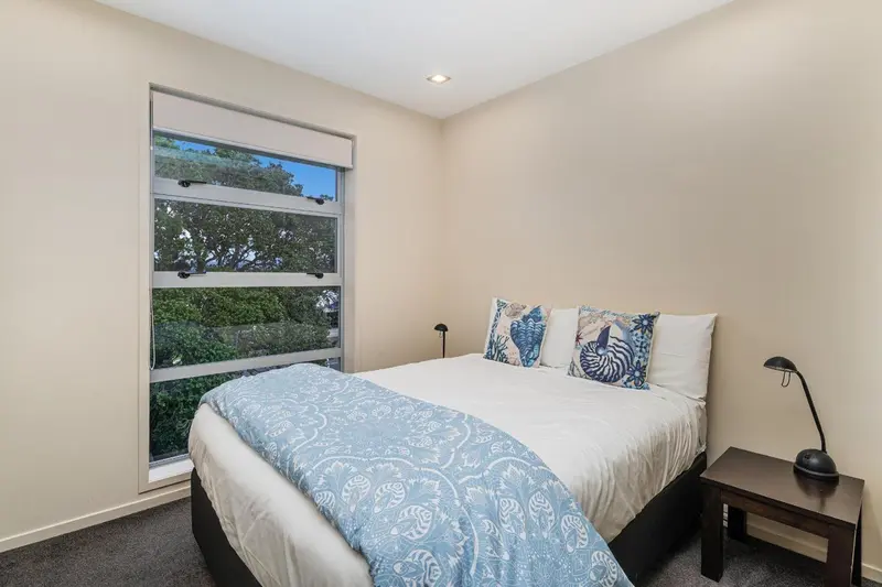Une chambre lumineuse avec un lit double et une fenêtre donnant sur la verdure.