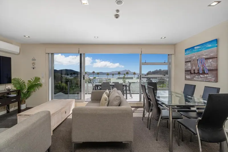 Un salon lumineux s'ouvre sur une terrasse avec vue sur la mer.