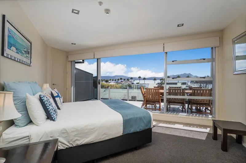 Une chambre lumineuse avec un grand balcon donnant sur la mer.