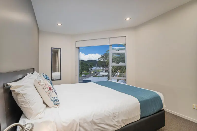 Une chambre lumineuse avec un grand lit donnant sur une vue dégagée.