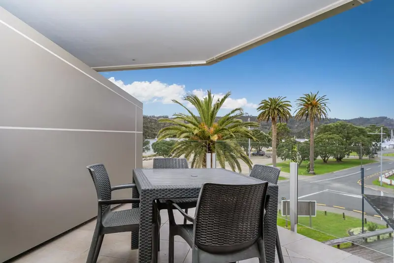 Terrasse avec mobilier en résine tressée donnant sur une vue verdoyante.