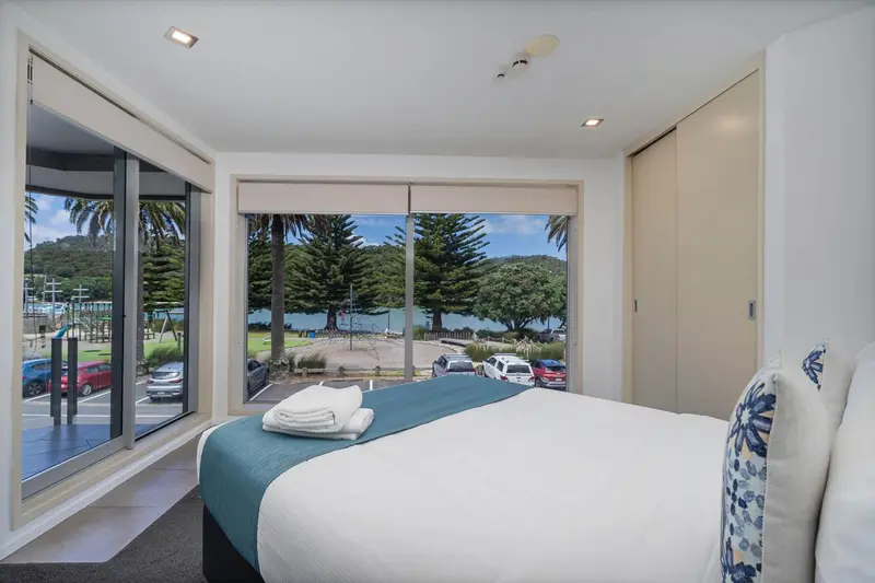 Une chambre lumineuse avec un grand lit donnant sur une vue sur la mer.