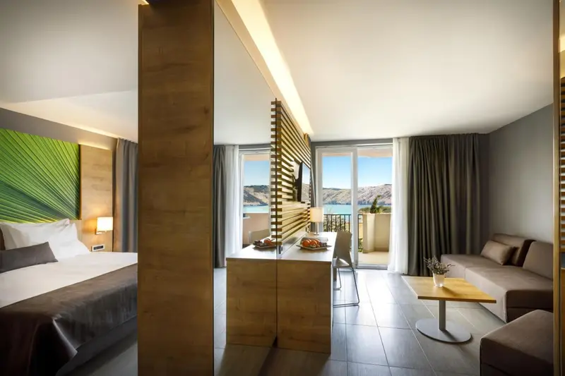 Espace de vie lumineux avec un lit, un coin repas et un canapé.