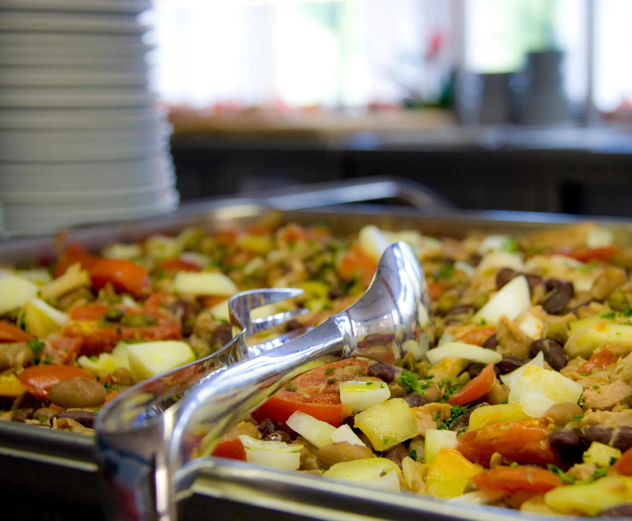 Un plat de salade colorée est présenté sur un buffet.