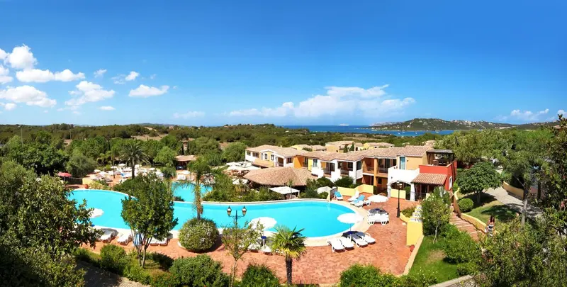 Vue aérienne d'un complexe hôtelier avec piscine et végétation luxuriante.