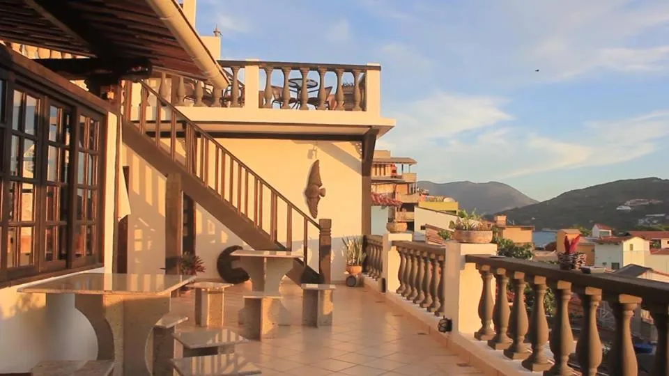 Terrasse ombragée avec escalier et vue sur un paysage montagneux.
