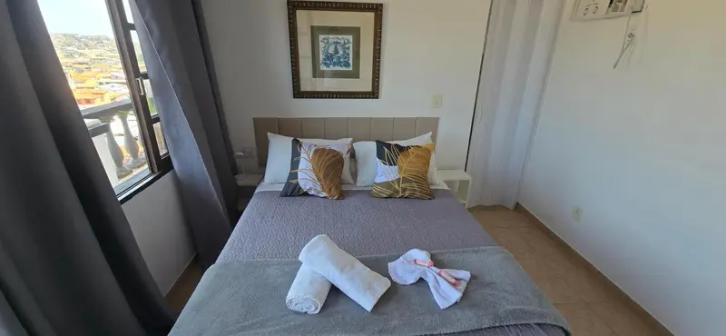 Une chambre avec un grand lit et une vue sur la ville.