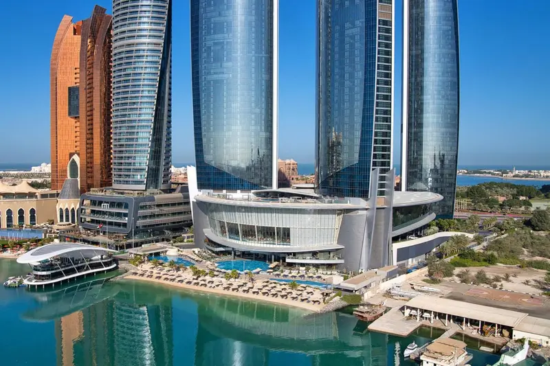 Vue aérienne d'un complexe hôtelier moderne avec piscine et accès à la mer.