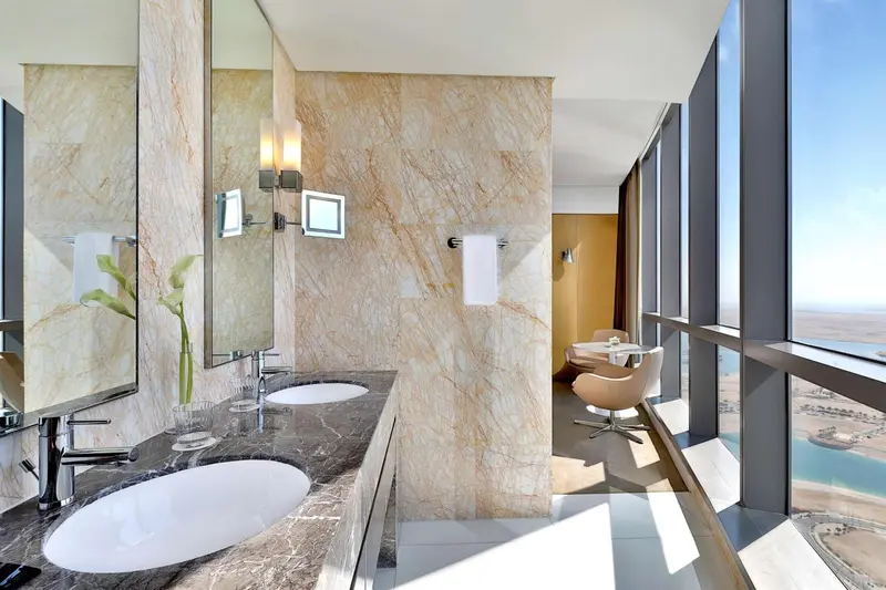 Une salle de bain moderne avec deux vasques et un grand miroir.
