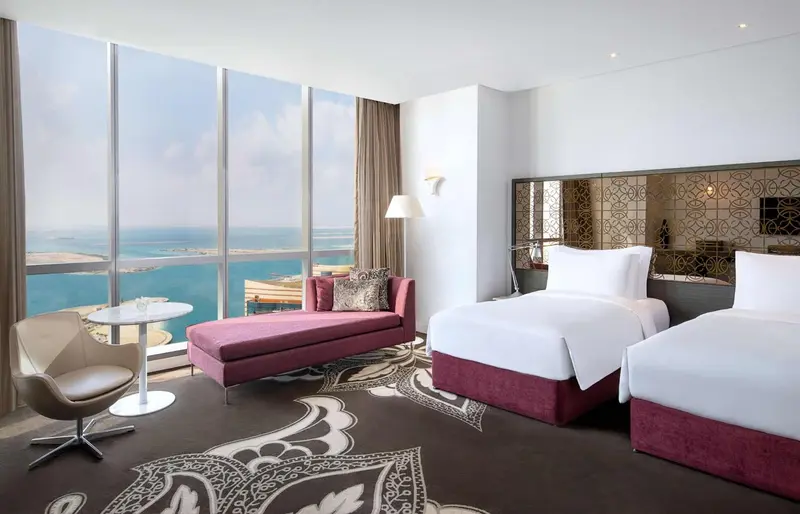Chambre d'hôtel moderne avec vue sur la mer et mobilier confortable.