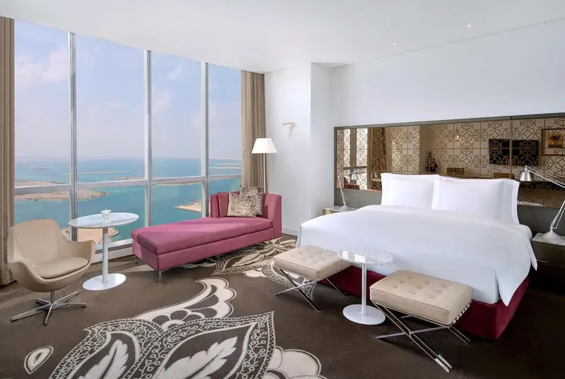 Chambre lumineuse avec un espace détente et vue sur la mer.