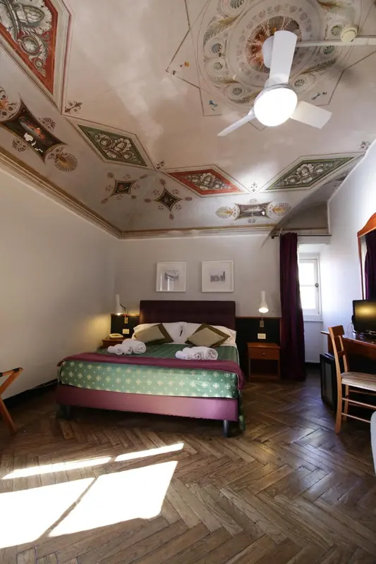 Chambre à coucher avec un lit décoré et un parquet en chevrons.