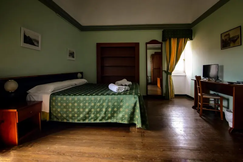 Une chambre lumineuse avec un grand lit et un bureau.