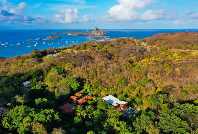 Vue aérienne d'une côte rocheuse avec des bâtiments et une végétation luxuriante.