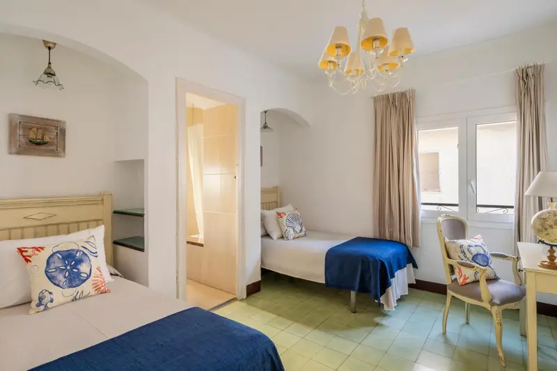 Une chambre lumineuse avec deux lits simples et une décoration marine.