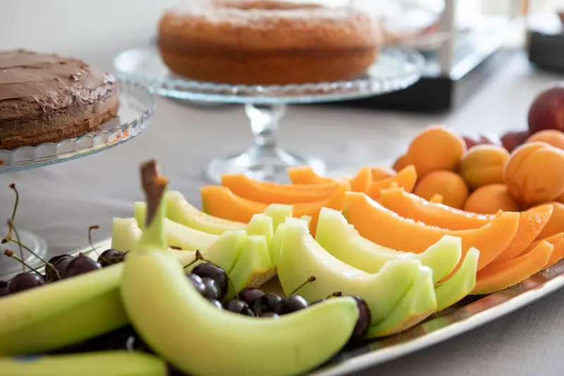 Assortiment de fruits frais et de pâtisseries sur un présentoir.