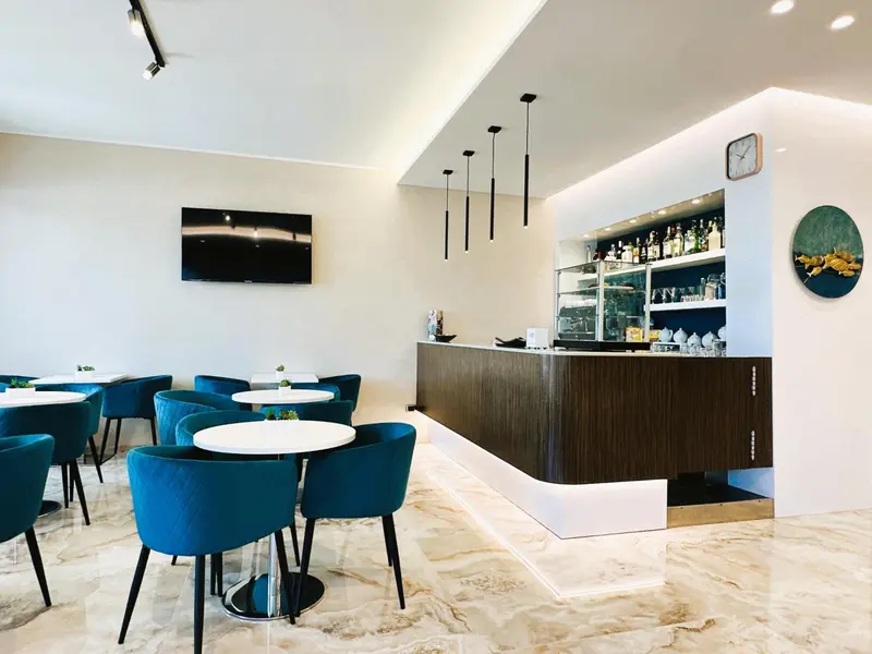 Une salle lumineuse avec un comptoir de bar et des tables.