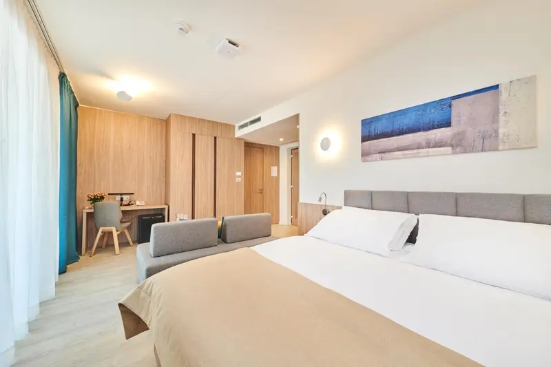 Une chambre lumineuse avec un lit double et un espace salon.