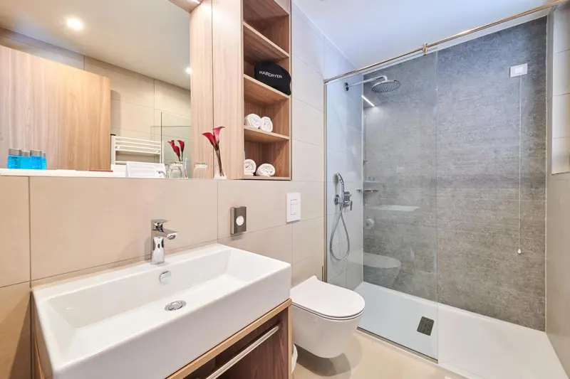 Une salle de bain moderne avec douche à l'italienne et vasque.