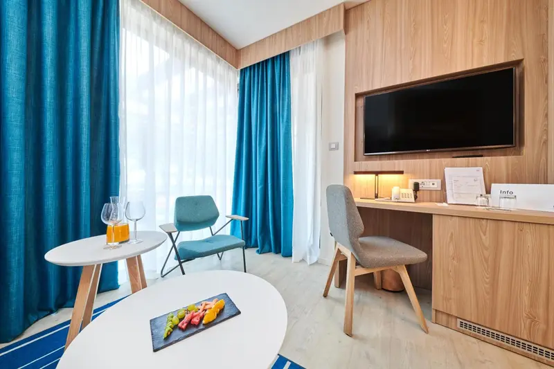 Une chambre lumineuse avec un coin salon et une table basse décorée de fruits.