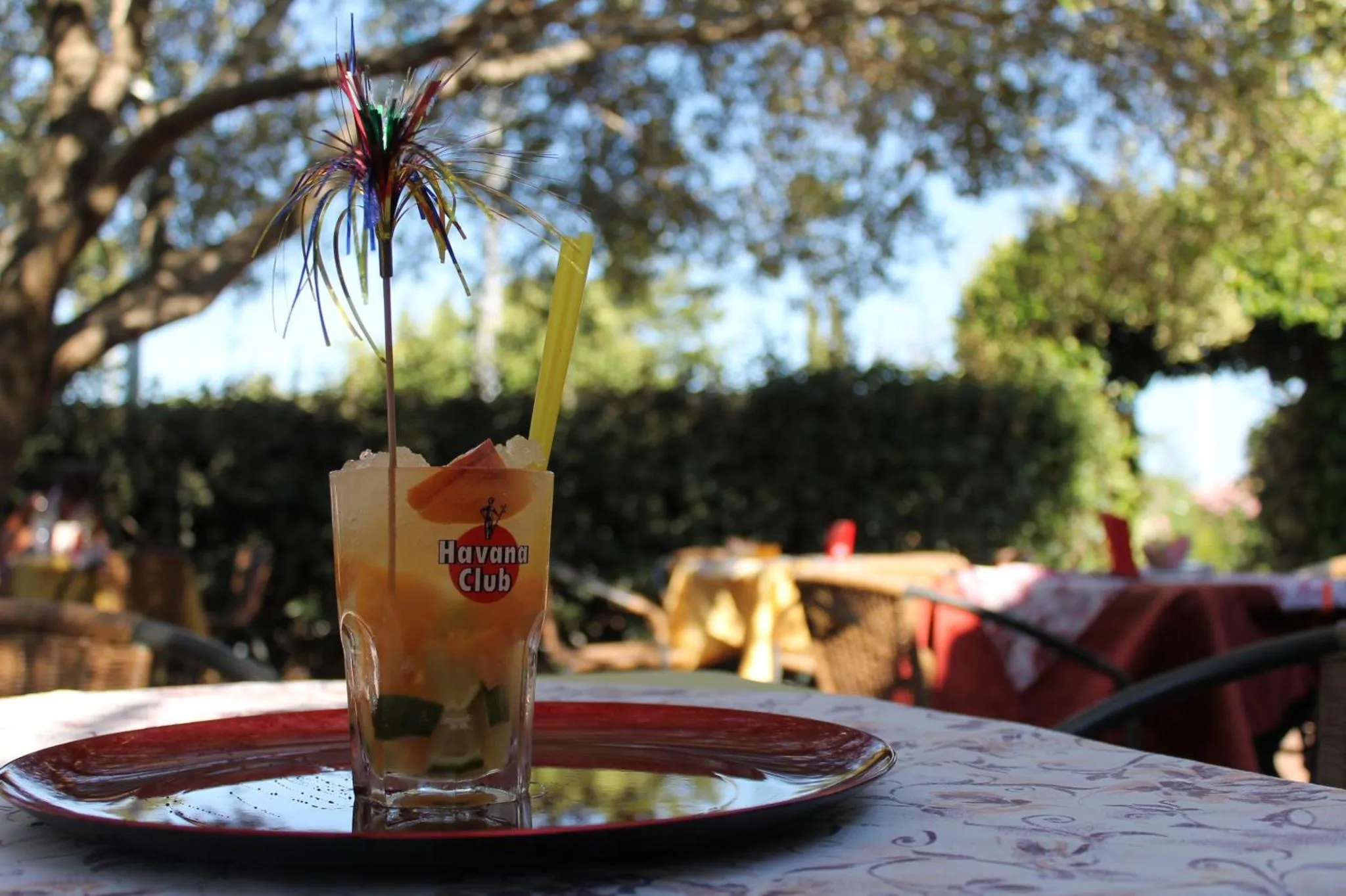 Un cocktail coloré est présenté sur une table en terrasse.