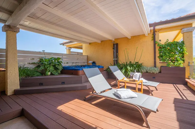 Terrasse aménagée avec transats et jacuzzi.