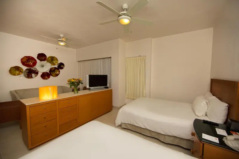 Une chambre lumineuse avec un lit et un meuble bas.