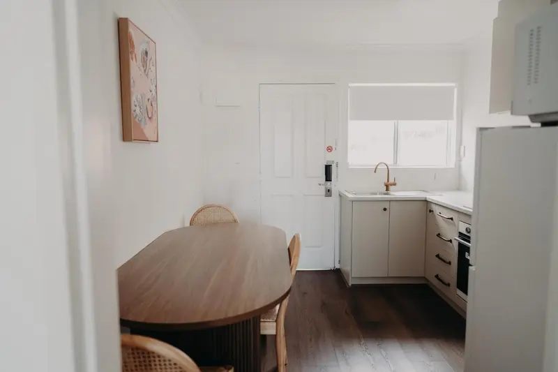 Une cuisine lumineuse avec une table à manger en bois.