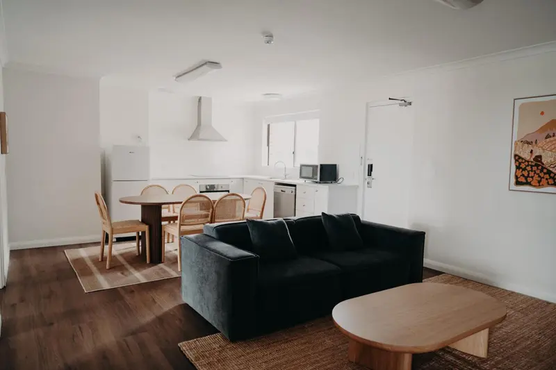 Espace de vie lumineux avec canapé et coin repas.