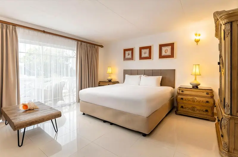 Une chambre lumineuse avec un grand lit et des meubles en bois.