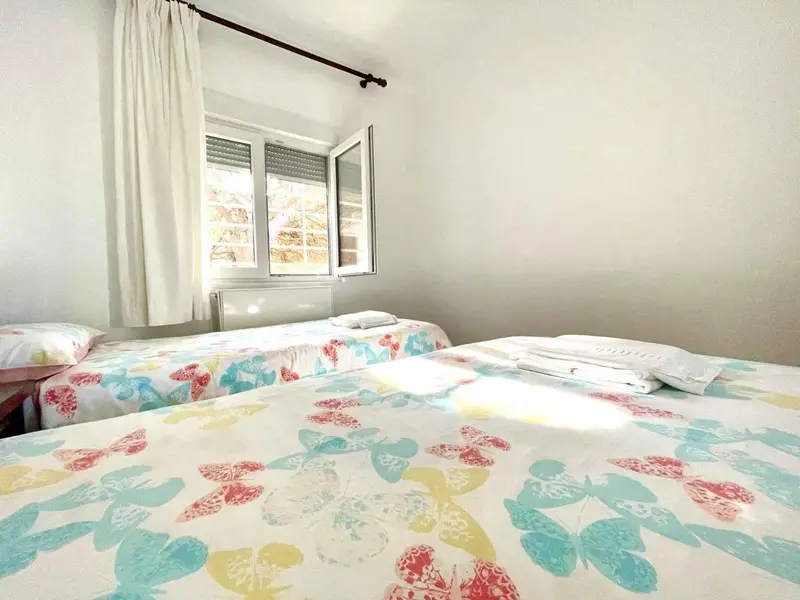 Une chambre lumineuse avec deux lits simples.